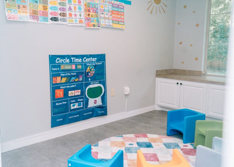 Autism therapy classroom setup with circle time area and learning visuals on wall.