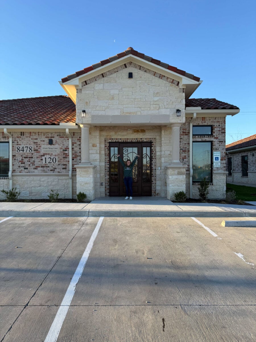 Front exterior of ABA therapy clinic building in Fort Worth with staff member at entrance.
